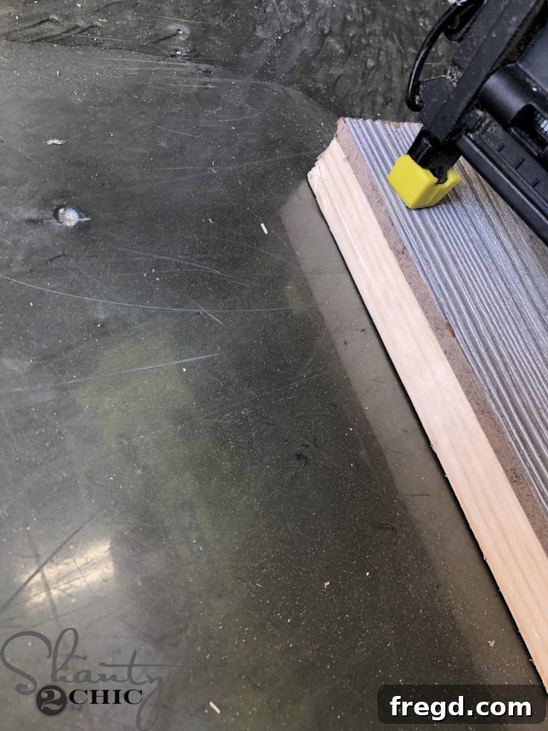 Attaching the Barn Wood MDF Panel to the barn door frame with staples and glue