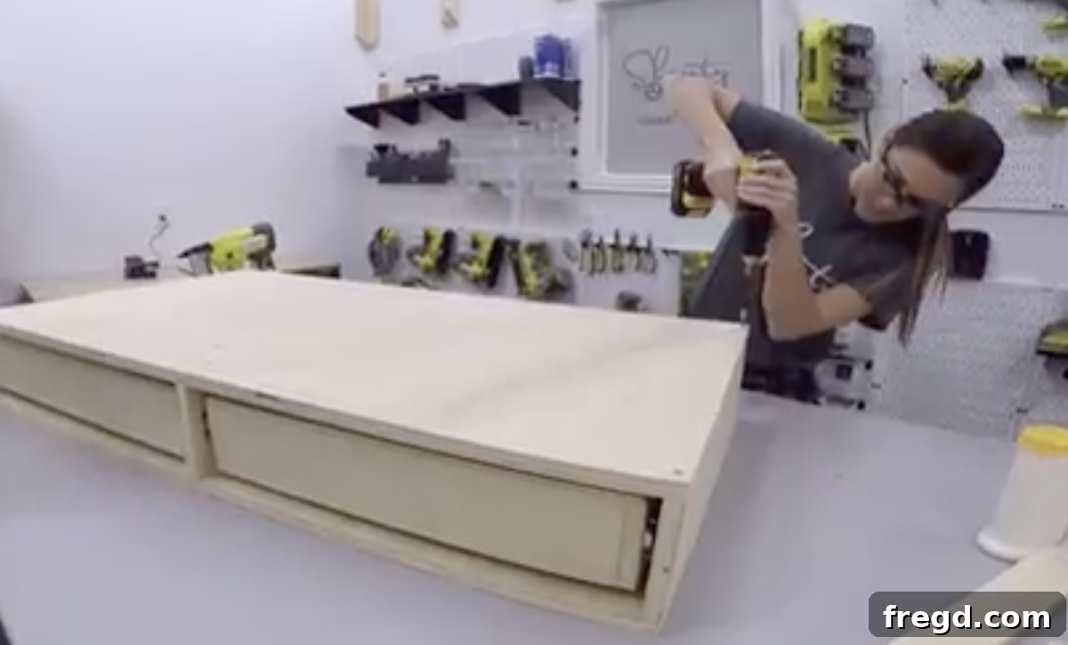 Attaching the fabricated table base to the coffee table top using wood glue and screws.