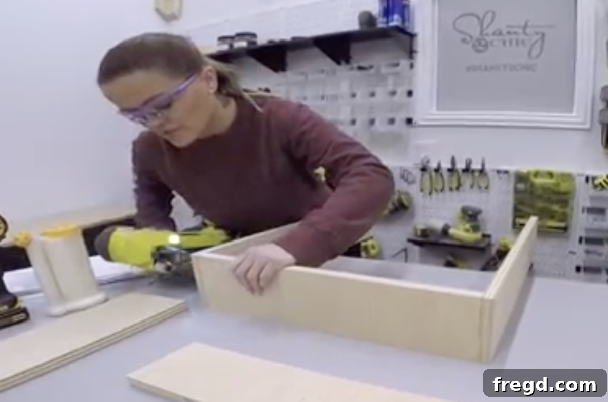 Assembling the wooden boxes for the coffee table drawers using wood glue and brad nails.