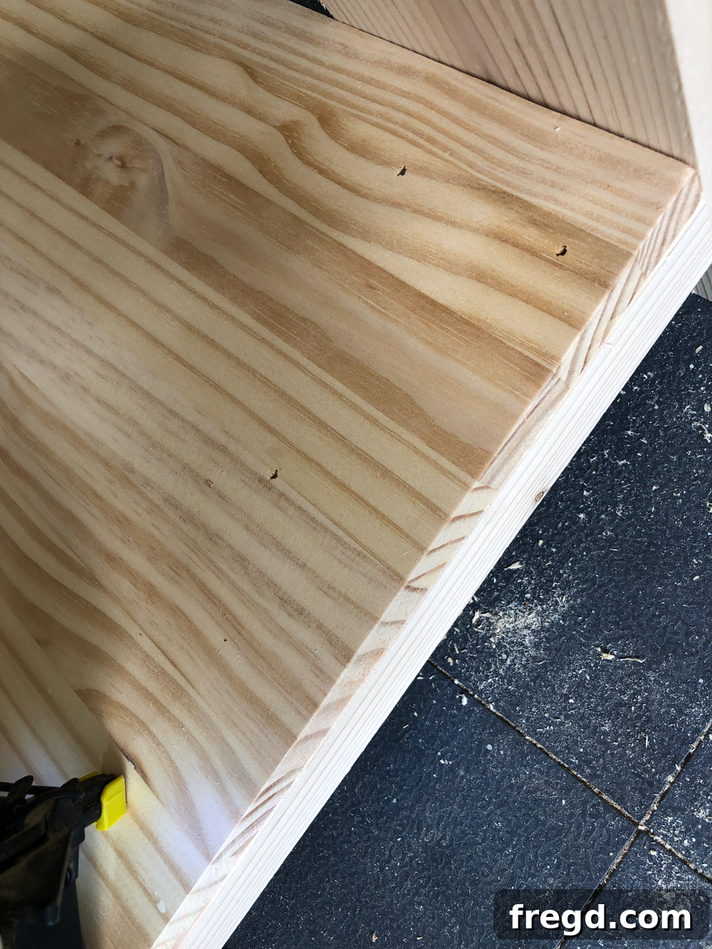 Build Your Own Faux Drawer Console Table 27 Securing the bottom shelf with brad nails, ensuring a strong and stable attachment.