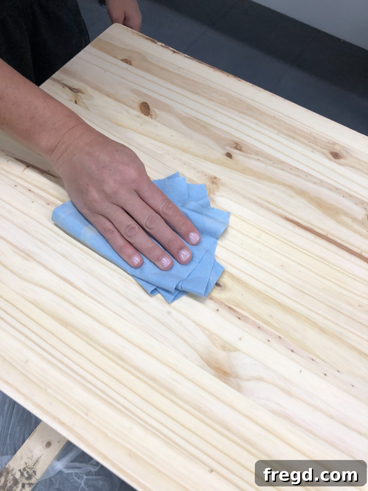 Wiping down the console table to remove sanding dust