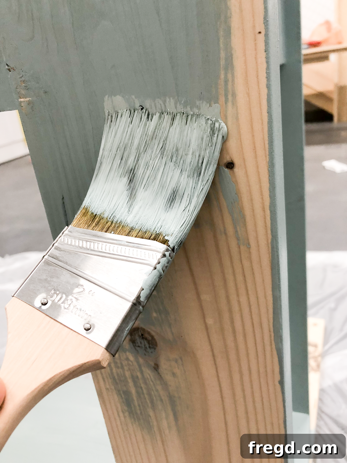 Applying the first coat of paint to the console table