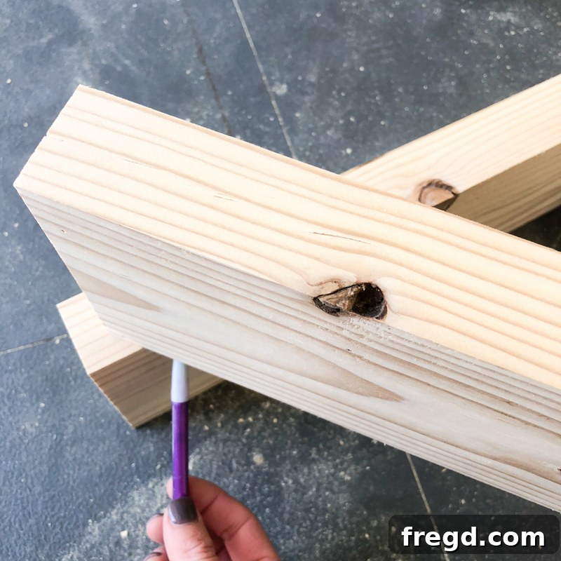 Sawhorse Chic: A DIY Modern Farmhouse Dining Table 13 Measuring and marking the angle for a diagonal brace on a wooden board