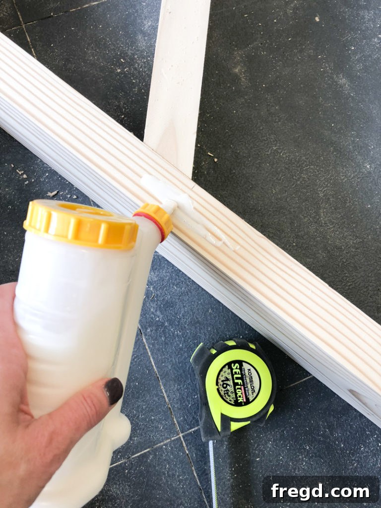 Sawhorse Chic: A DIY Modern Farmhouse Dining Table 18 Wood glue being applied to the joint for a leg brace