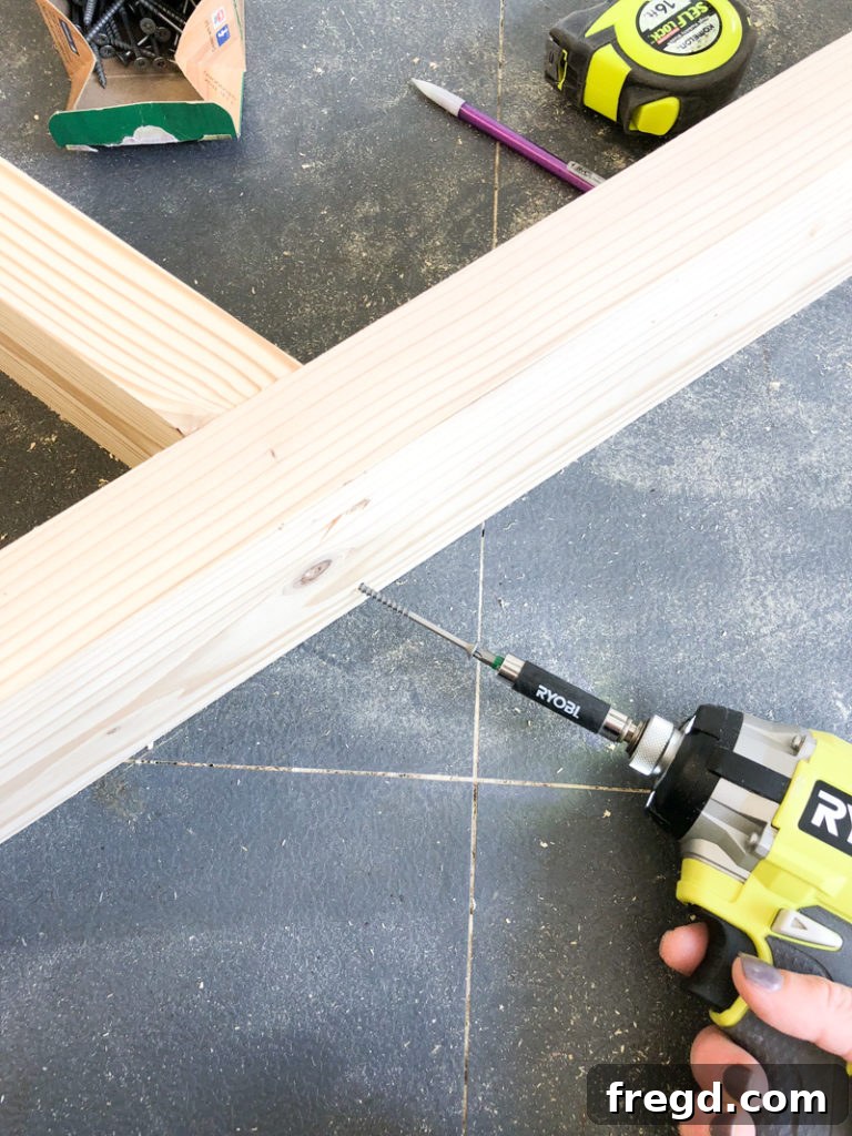 Sawhorse Chic: A DIY Modern Farmhouse Dining Table 8 Close-up of wood glue being applied to a joint during table base assembly