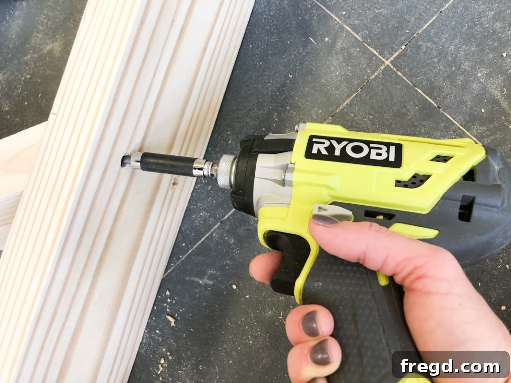 Sawhorse Chic: A DIY Modern Farmhouse Dining Table 9 Using a power drill to fasten wood pieces together with screws for the table base