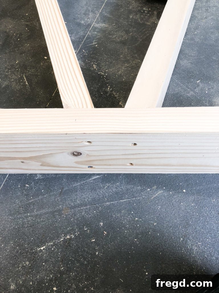 Sawhorse Chic: A DIY Modern Farmhouse Dining Table 10 A GluBot bottle dispensing wood glue precisely onto a wooden joint