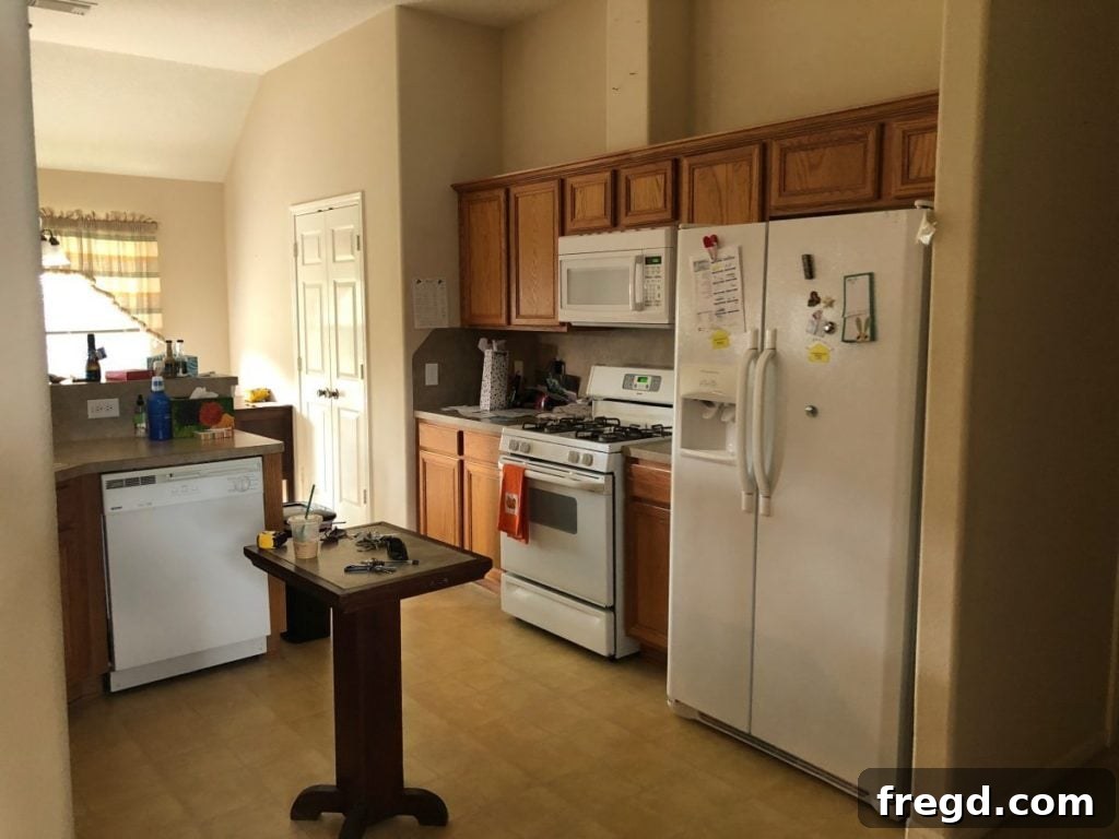 Before photo of an outdated kitchen with short cabinets that don't reach the ceiling.