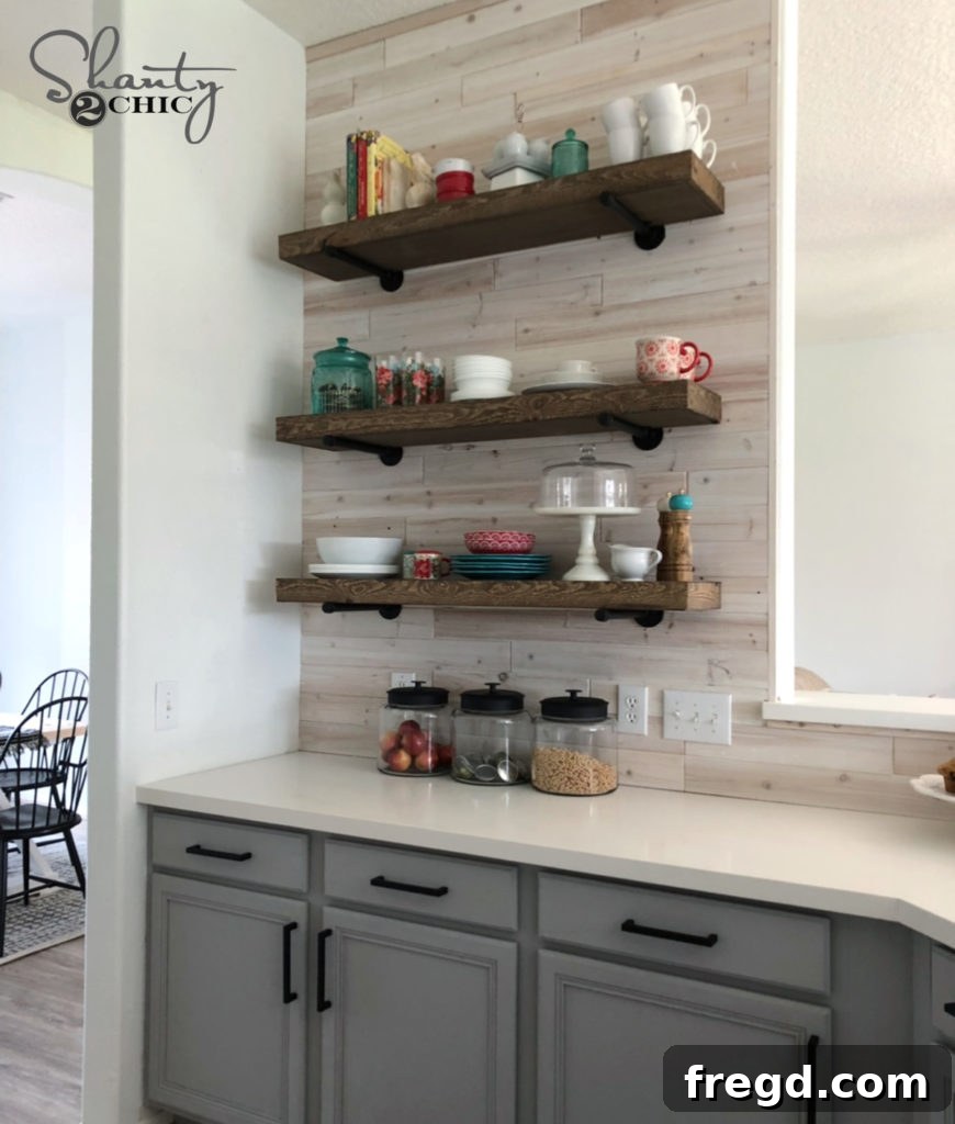 After photo of the kitchen featuring cute floating shelves and a unique DIY driftwood backsplash, adding character and warmth.