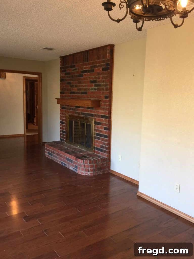 Another before view of the double fireplace in the Davis home, highlighting the cluttered and non-focal design.
