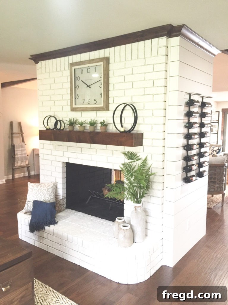 After photo of the Davis home's double fireplace, now painted white and trimmed, serving as a bright focal point.