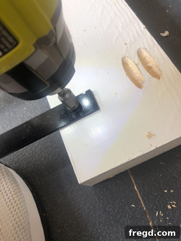 Attaching black aluminum flat bars to the wooden side frame pieces with self-tapping screws