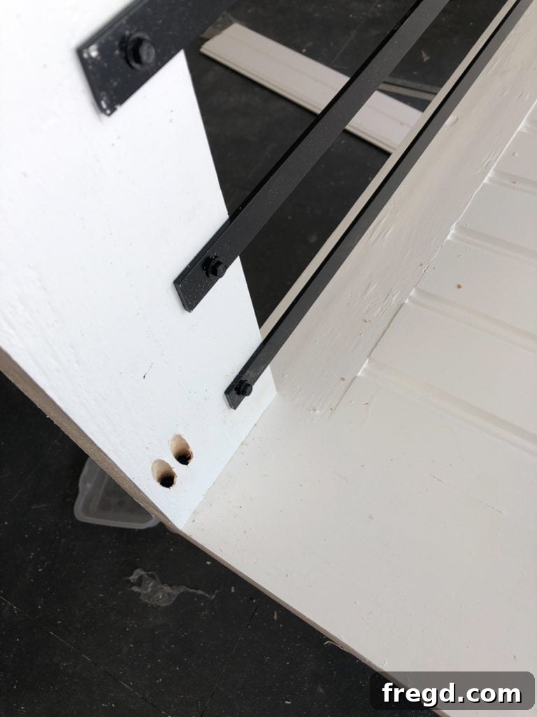 Attaching the assembled side panel to the back frame of the dog crate using wood glue and pocket hole screws