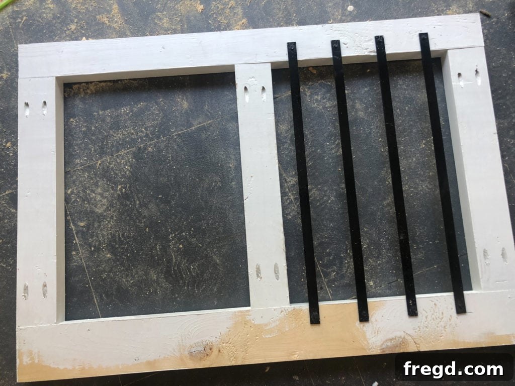 The front half of the dog crate frame with black metal bars already attached, showing the defined opening