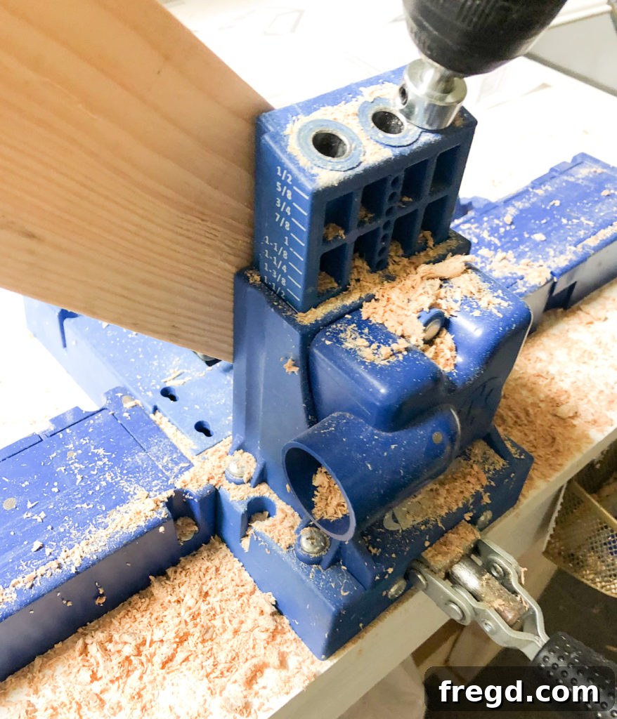 Drilling 1.5-inch pocket holes into the angled ends of the 2x4 lumber for the crate base