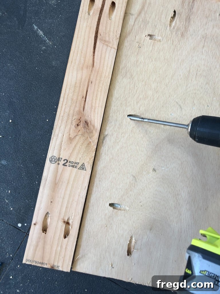Attaching the vertical frame pieces to the back plywood panel using wood glue and pocket hole screws