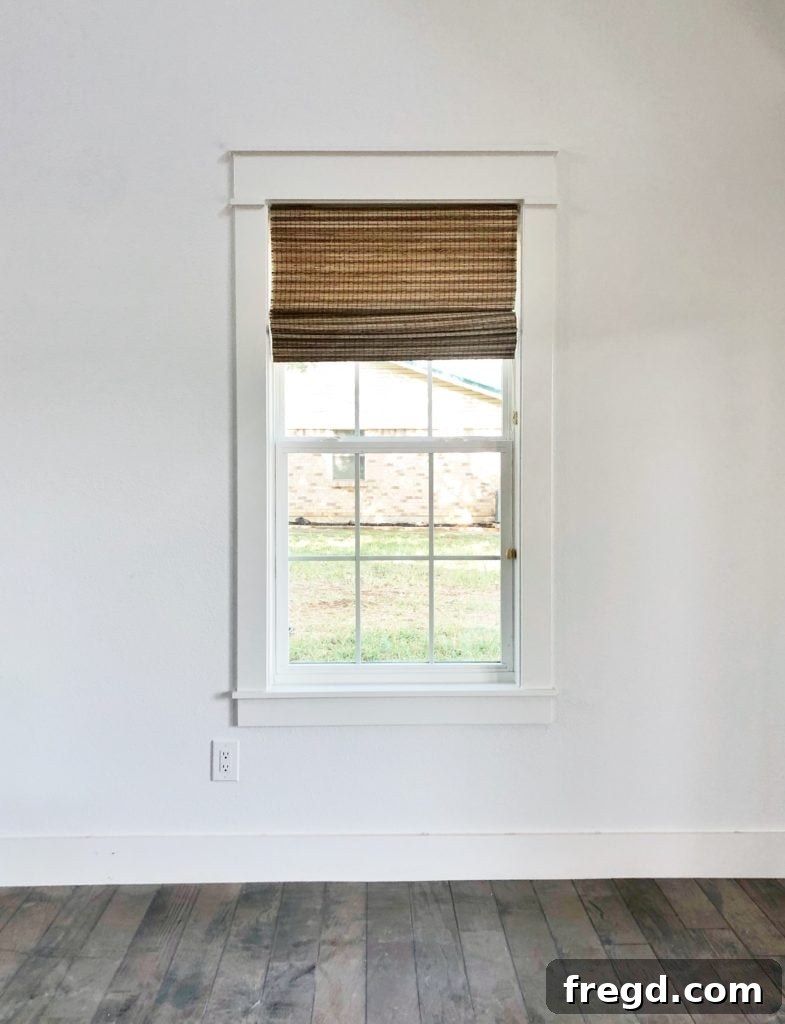Shanty2Chic Tackles Flip House Four 9 Another vertical view of the great room, focusing on a window with Graber natural shades and custom trim, alongside curated home decor elements, emphasizing natural light.