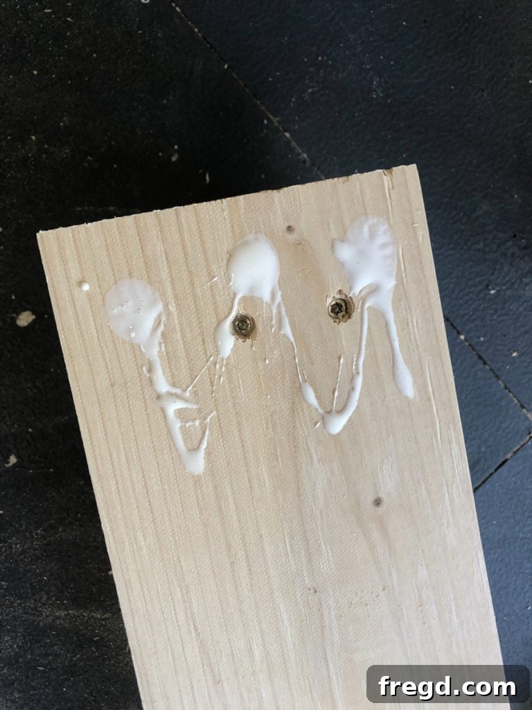 Close-up of laminated wood leg showing the arrangement of screws for structural integrity.