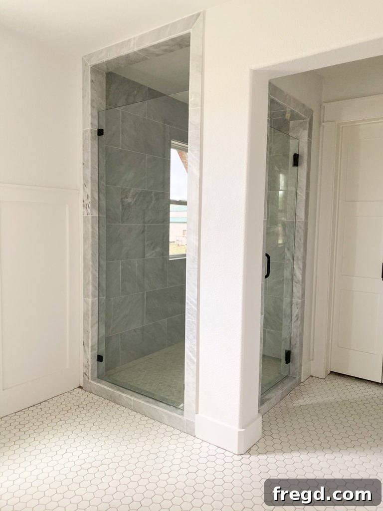 Luxurious master bathroom shower featuring large grey marble tiles on the walls.