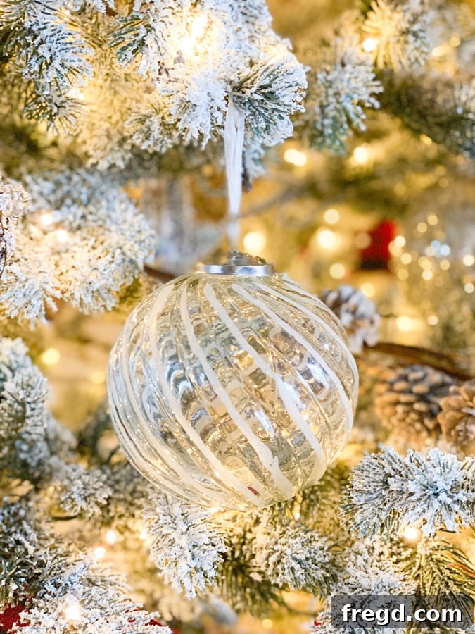 Sylvan Charm Christmas Tree 10 Elegant silver ball ornament with intricate textured detailing.