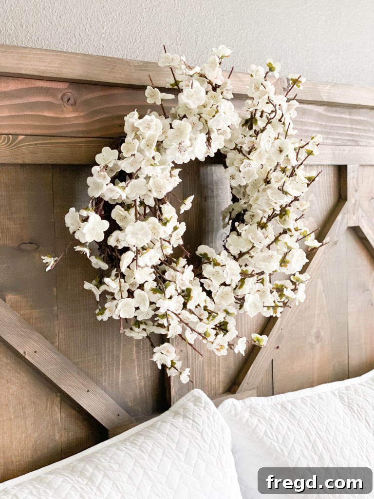 Delicate plum blossom wreath thoughtfully attached to a rustic wooden headboard, blending nature with comfort.
