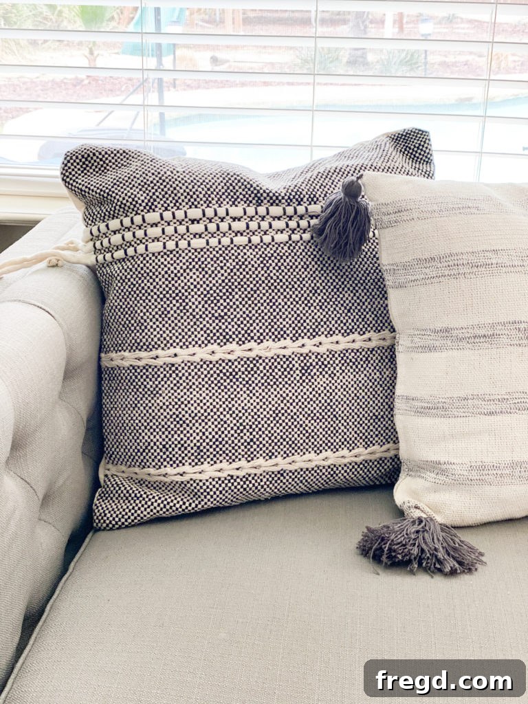 A stylish throw pillow featuring a modern geometric weave in contrasting black and white tones.