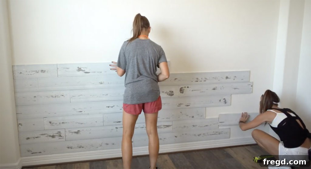 Quick and Easy Wood Plank Wall Upgrade 3 Close-up of wood planks being installed, highlighting the staggered seam pattern for a natural look