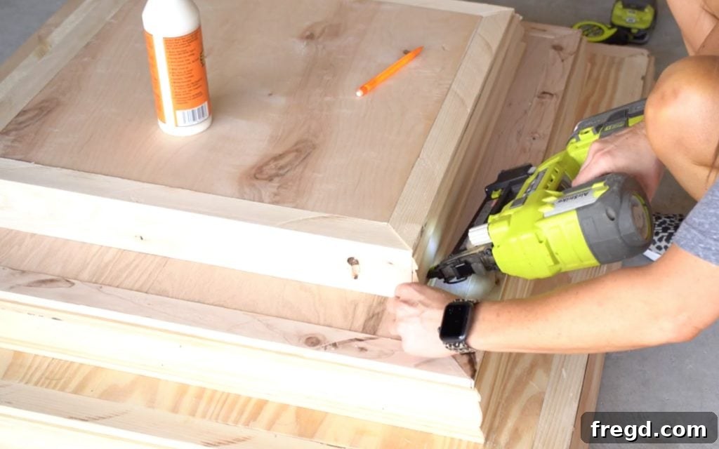 Applying trim to the third base frame, completing the tiered base.
