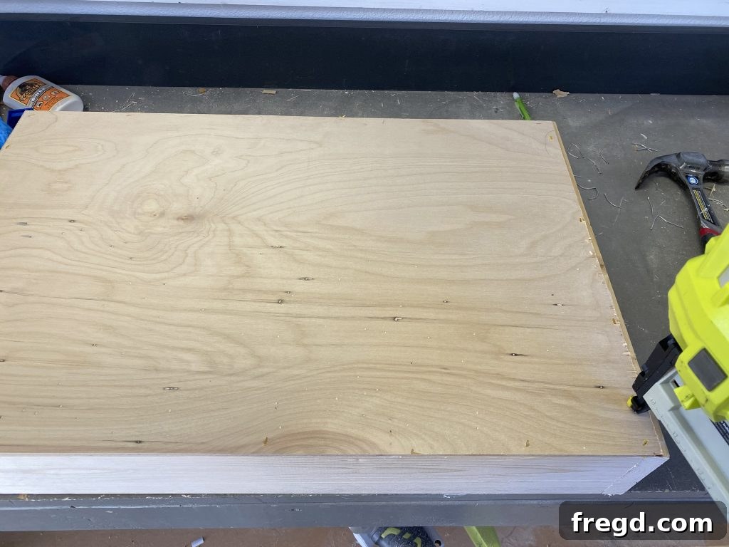 Attaching the drawer bottom to the drawer frame with staples and wood glue