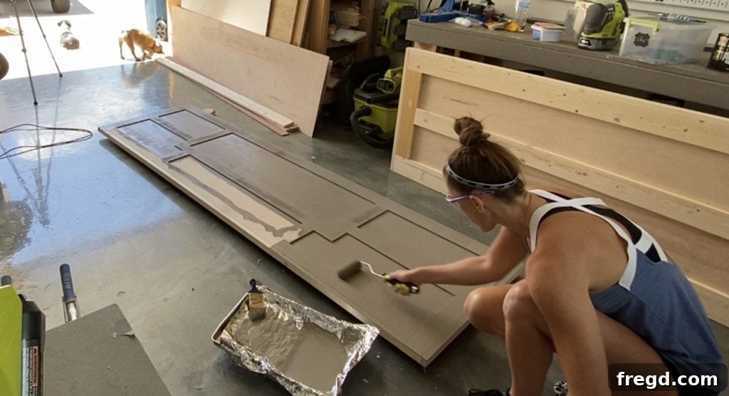 Applying the first coat of paint to the sanded barn door.