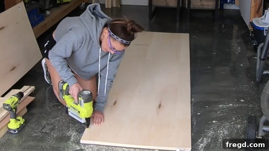 Attaching the hardwood plywood backing to the assembled wooden frame.