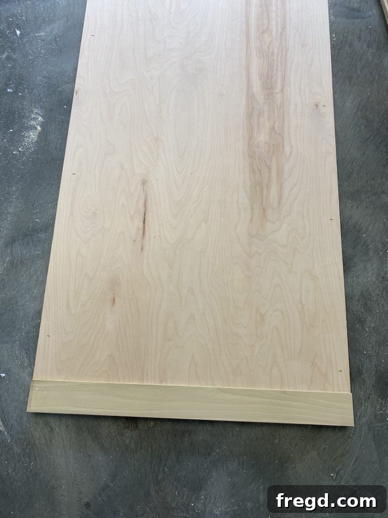 Starting to attach the front outside trim pieces to the plywood backing.