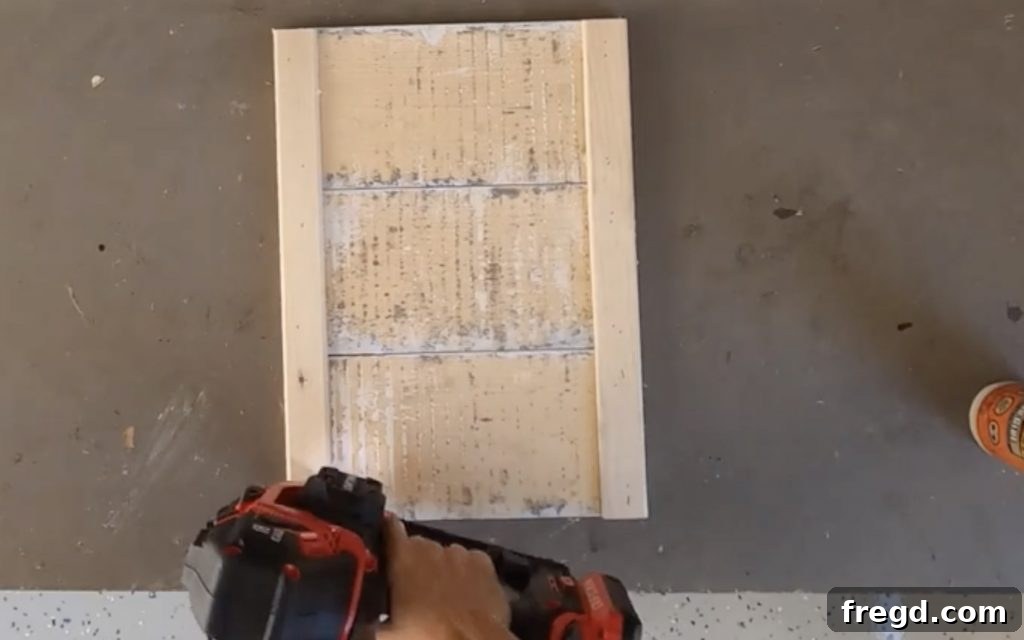 Nailing back supports to barnwood planks with brad nails.