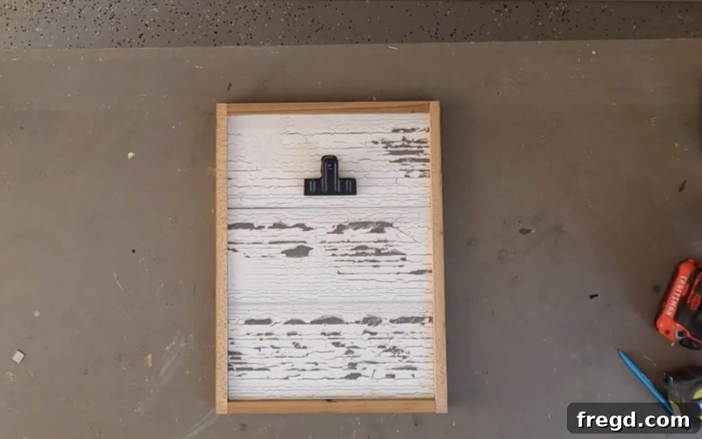 Centering and hot gluing a bulldog clip to the top of the frame.