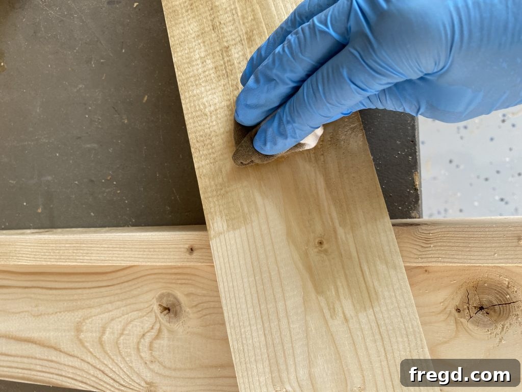 Your DIY Dry Erase Canvas 18 Applying custom mixed Minwax stain to the wooden frame of the dry erase board with a cloth