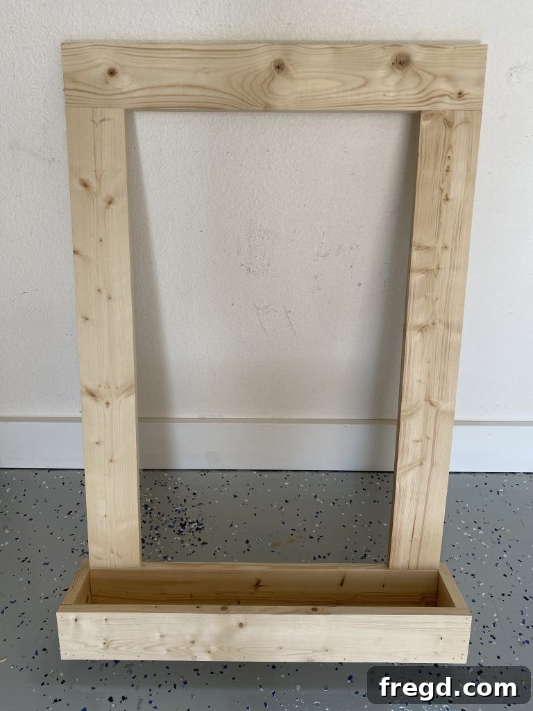 Your DIY Dry Erase Canvas 11 Front piece of the cup holder being nailed into place on the DIY dry erase board frame