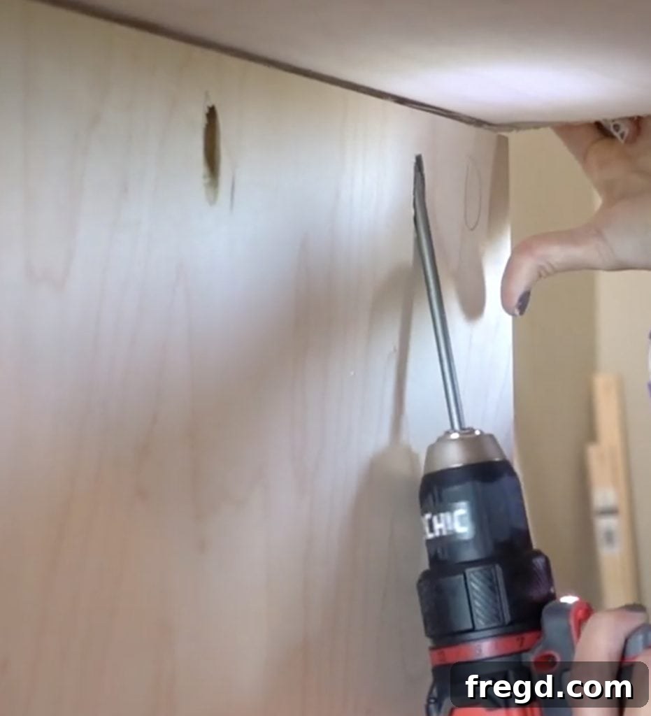 Middle divider being installed and centered inside the cabinet