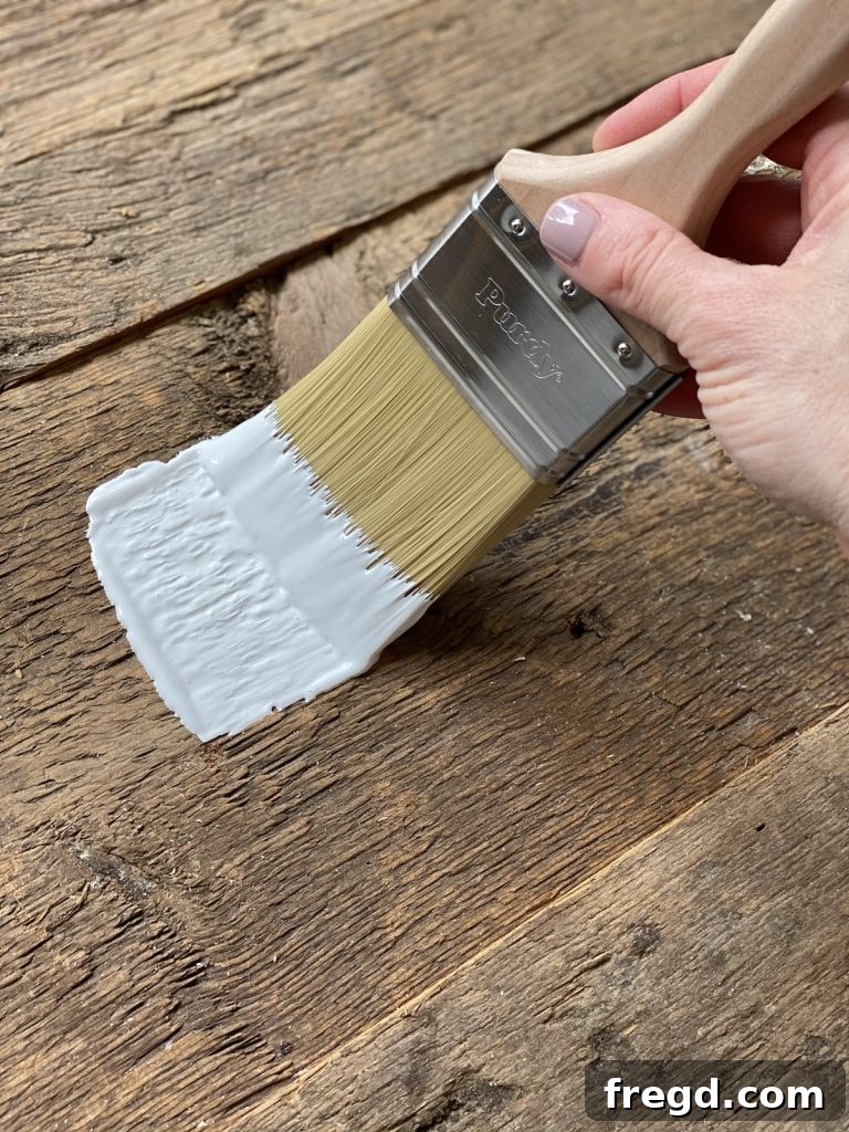 The barn wood surface almost fully painted with a single, thick coat.