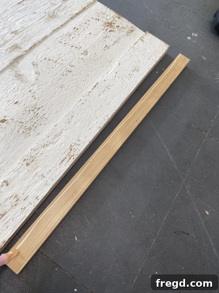 Attaching the stained 1x2 frame to the distressed barn wood display with wood glue and brad nails.