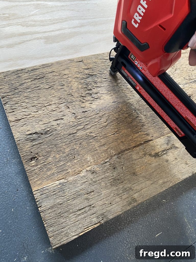 Detailed view of barn wood being progressively attached to the plywood backing.