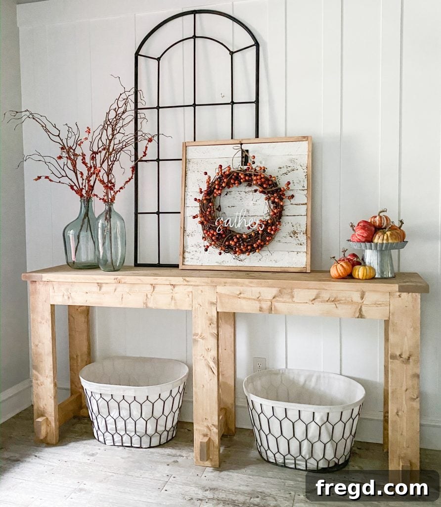 Beautifully decorated DIY farmhouse console table in an entryway, showcasing its rustic charm.