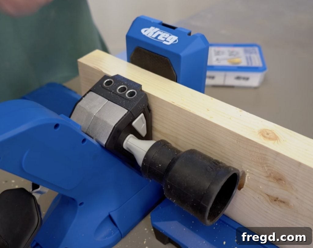 Kreg Jig 720PRO chip ejection port connected to a shop vacuum for efficient dust collection and a cleaner woodworking environment.