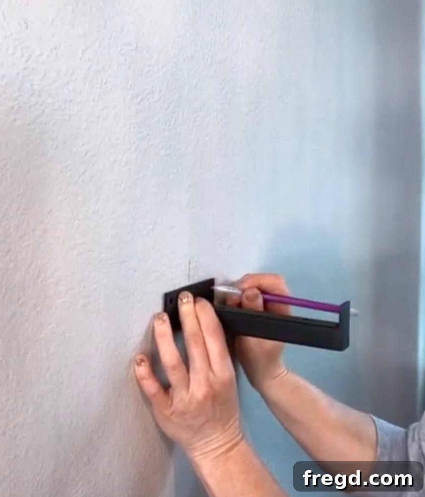 Inexpensive DIY Wall Shelves 8 Marking screw hole positions on a wall with a pencil for shelf bracket installation