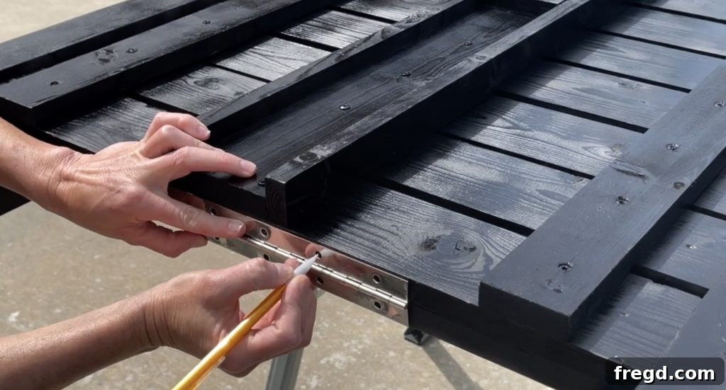 Laying the top slat assembly on the bottom slats for hinge attachment