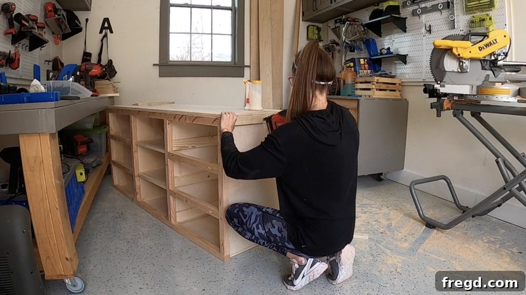 Attaching side trim pieces to the cabinet, flush with the face frames.