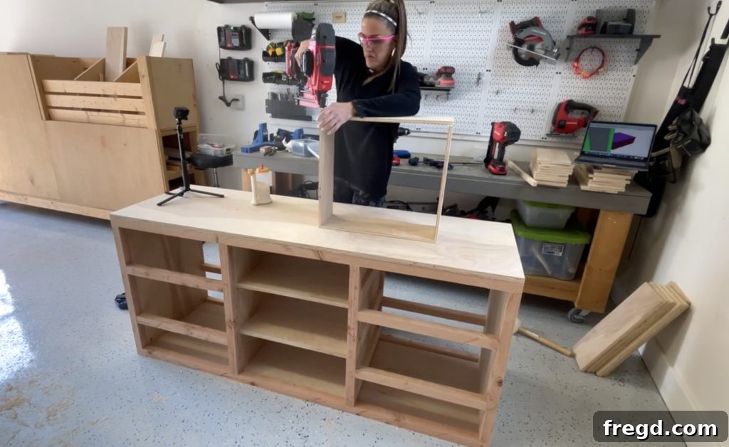 Assembling drawer front and side pieces with brad nails and wood glue.
