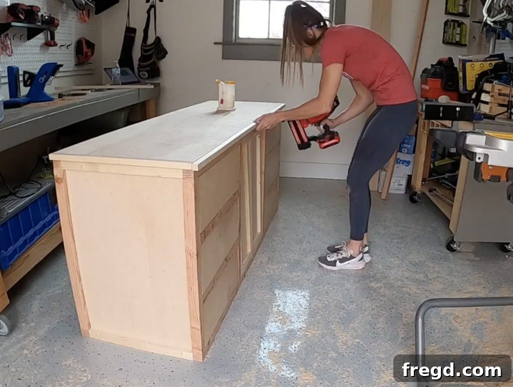Attaching side and front/back trim pieces to the top plywood sheet for a finished edge.