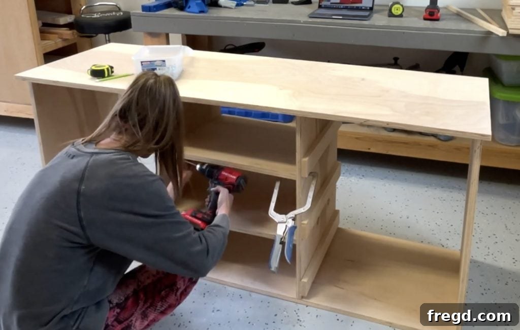 Installing internal shelf pieces with pocket holes into the cabinet frame.