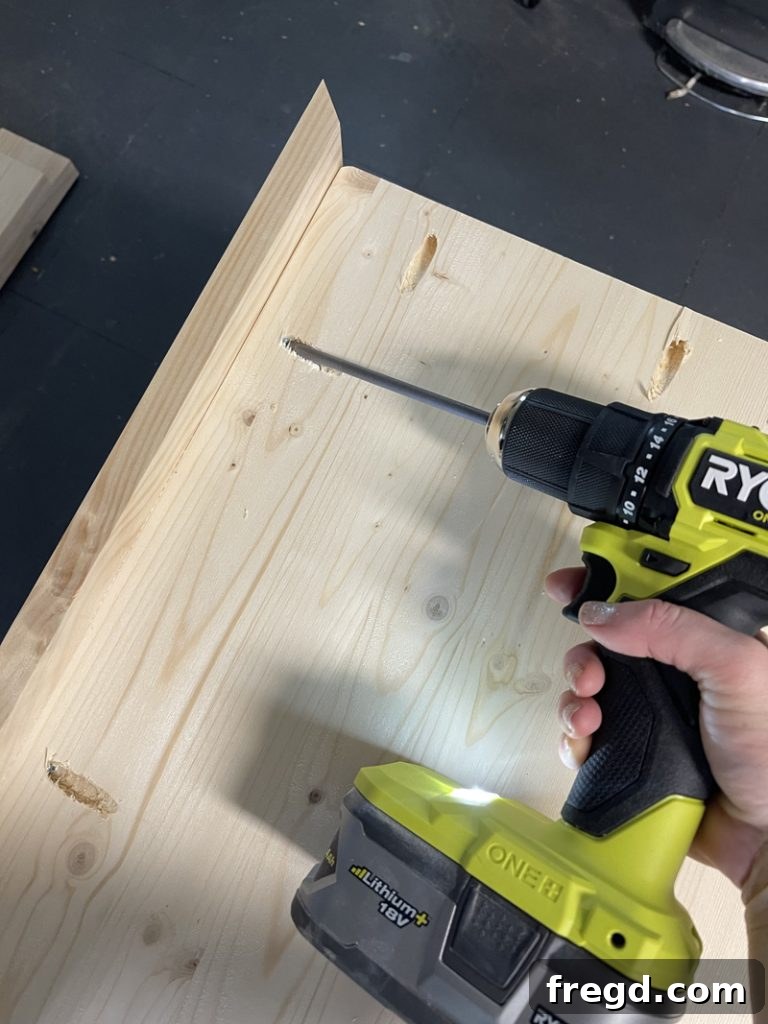 A completed corner of the tabletop, showing two mitered trim pieces securely attached with pocket hole screws.