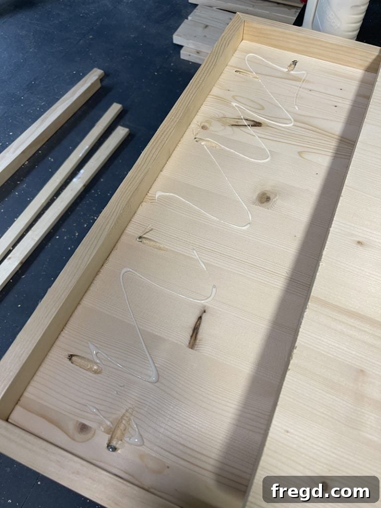 A piece of scrap wood being cut to size to create a leg support board for the table.